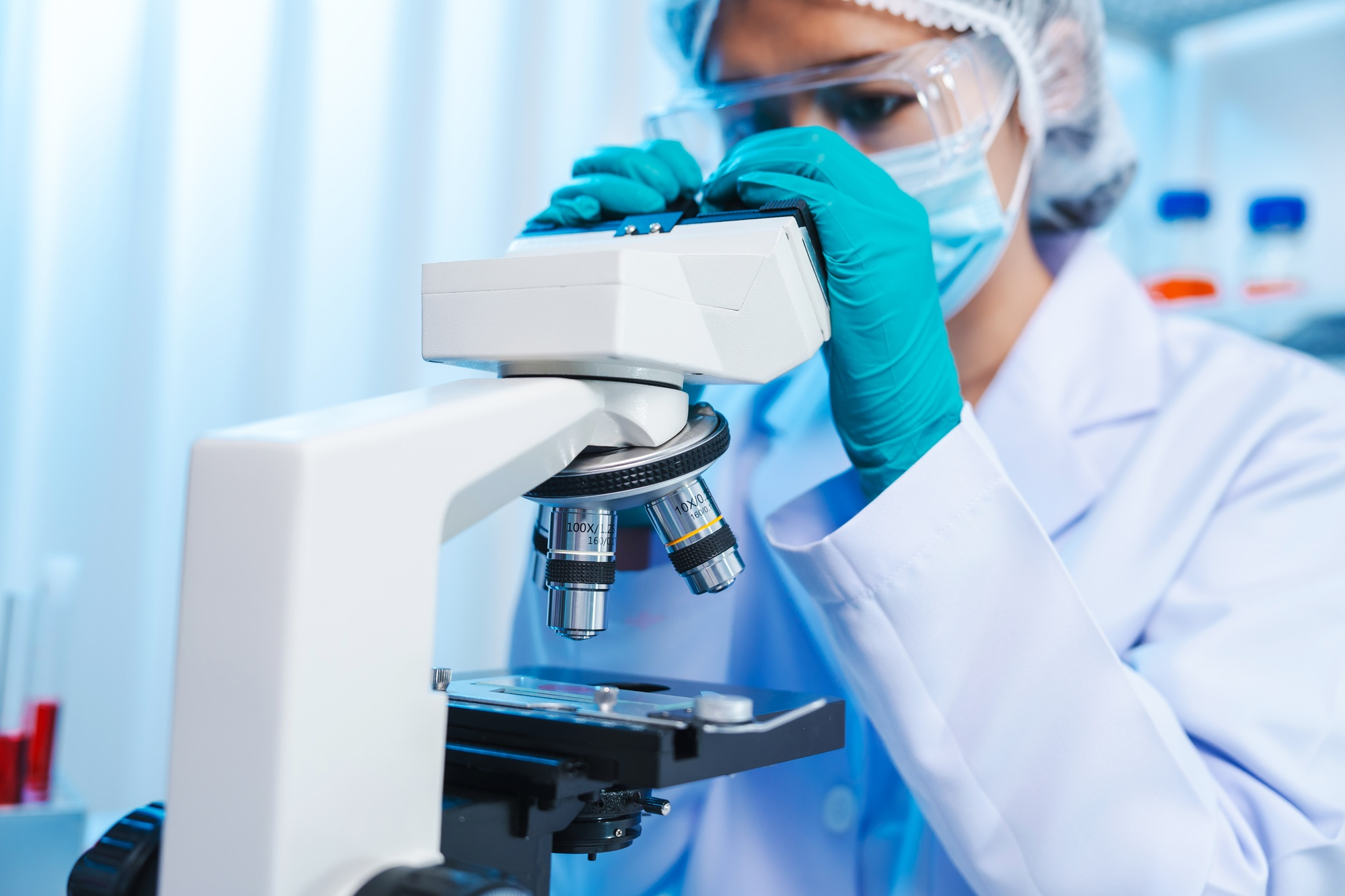 Asian people scientist in lab coat and protective gloves working with test tubes